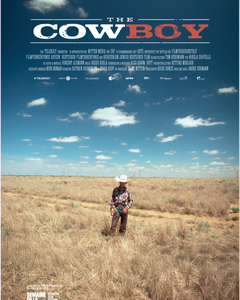 The CowBoy Filmplakat: Ein Cowboy steht in einem weiten, trockenen Feld unter einem blauen Himmel.
